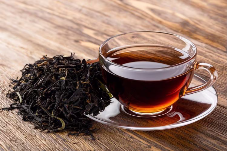 Dark black tea leaves in a ceramic dish