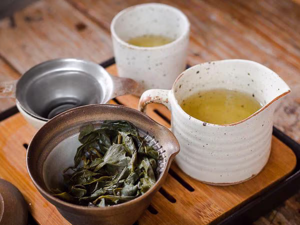 Rolled oolong tea leaves in a white porcelain bowl